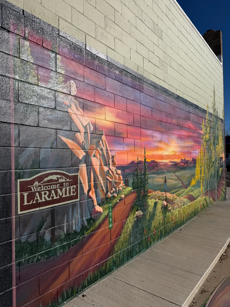 Angled view of the Welcome to Laramie mural showing the painted sign panel